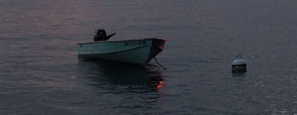 Sunset light across Lake Wentworth, New Hampshire glints off a cousin's boat. Photo by Santa Fe artist Dawn Chandler