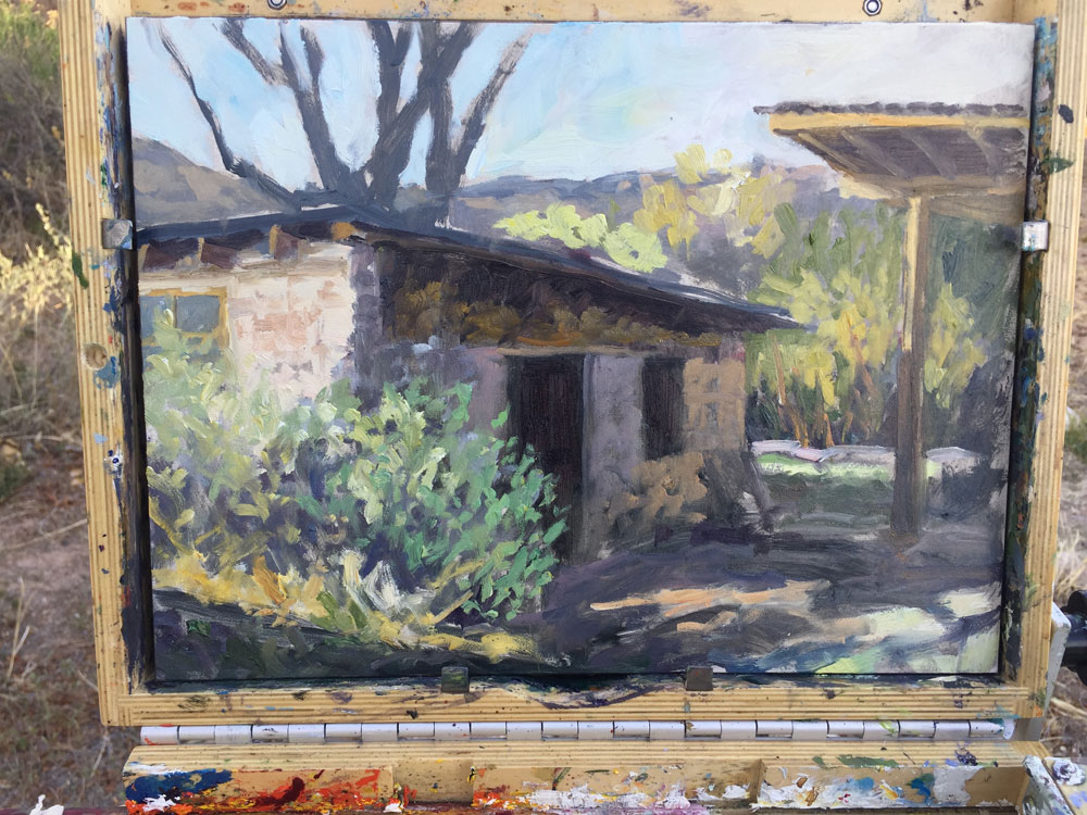 Dawn Chandler's laying in the color on a plein in painting of an adobe pottery shed in Dixon, New Mexico