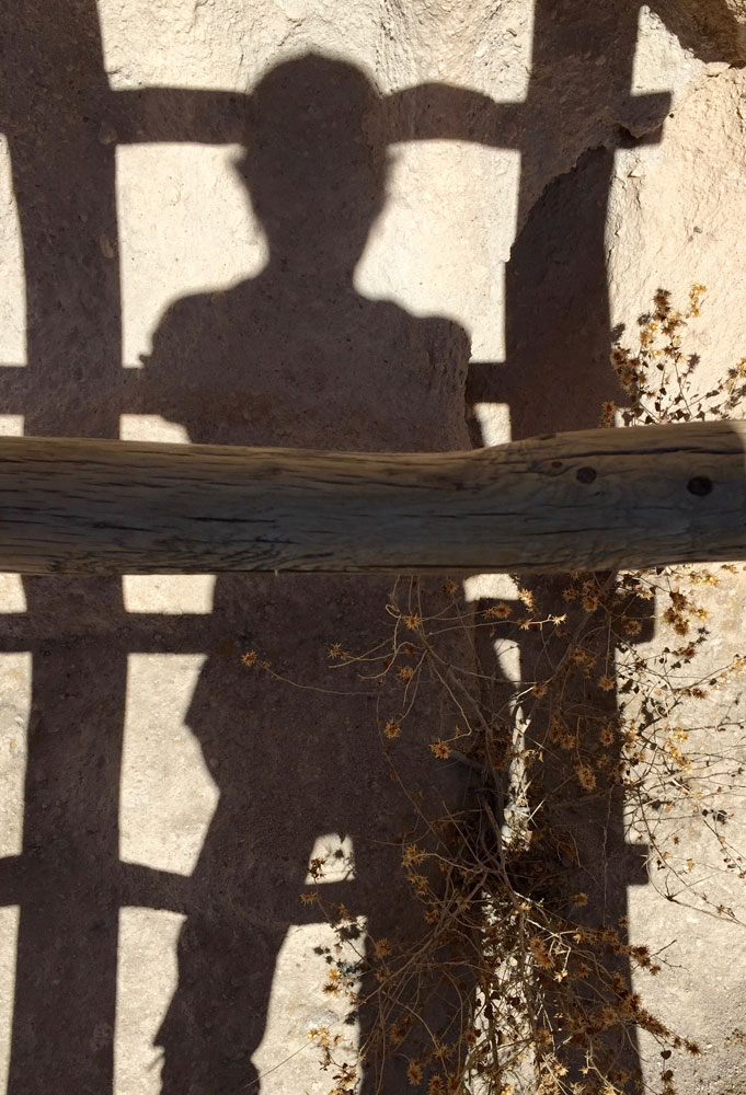 artist Dawn Chandler's shadowed silhouette against the canyon wall at Bandelier