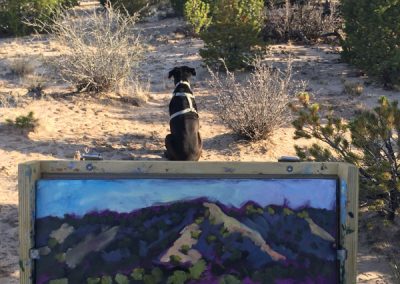 Artist Dawn Chandler being guarded while painting en plein air outside of Santa Fe