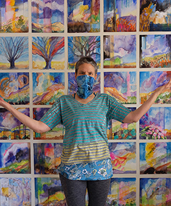 New Mexico artist Dawn Chandler safely social distancing in her Santa Fe studio among her watercolor paintings.