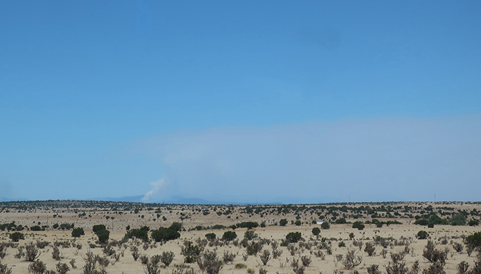 Distant fire haze and a definite smoke plume as seen from I-40 in New Mexico May 2022. Photo by Dawn Chandler.