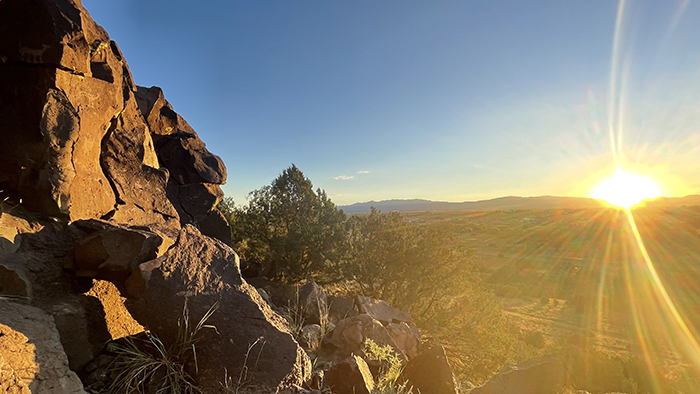 History and mystery in the New Mexico landscape: Sunrise over the Sangre de Cristos from the Cieneguilla petroglyphs in the Caja del Rio. Photo by Dawn Chandler.