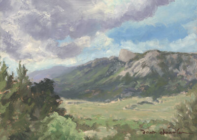 'At the Edge of the High Country' original New Mexico landscape painting in oil by Santa Fe artist Dawn Chandler, featuring Philmont’s Tooth of Time Ridge seen from The Nairn Place (now Casa del Gavilan) on an afternoon, with sunlit meadows leading up to the rugged mountain slope beneath dramatic blue and cloud‑filled skies.