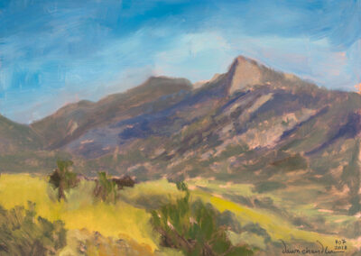 ‘A Philmont Morning Is the Best Kind of Morning’ original New Mexico landscape painting in oil by Santa Fe artist Dawn Chandler, depicting the Tooth of Time rising above a sunlit grassy meadow and winding trail beneath a luminous blue and lavender morning sky.