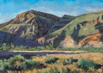 Before the Day Took Hold’ original Oregon landscape painting in oil by Santa Fe artist Dawn Chandler, depicting early morning light across golden grasses and sagebrush below rugged canyon cliffs and rolling green hills near Lake Owyhee in eastern Oregon.